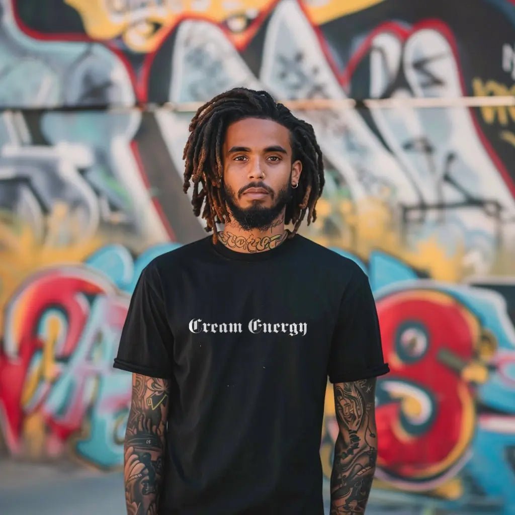 Man in a black Cream Energy tee in front of a graffiti wall